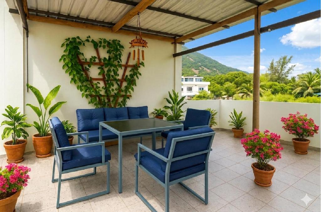 a patio with blue chairs and a table at La Nuit Étoilée , Restez plus, payez moins ! in La Gaulette