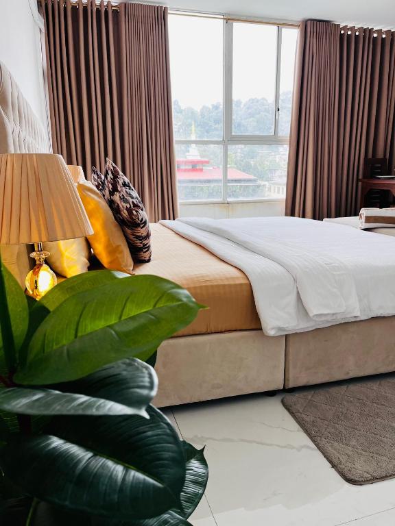 a bedroom with a bed and a large window at Ruish City Kandy in Kandy