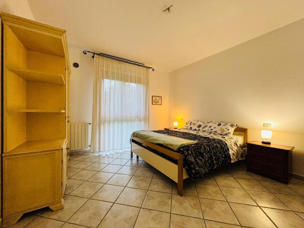 a bedroom with a bed and a large window at La casetta in Pontedera