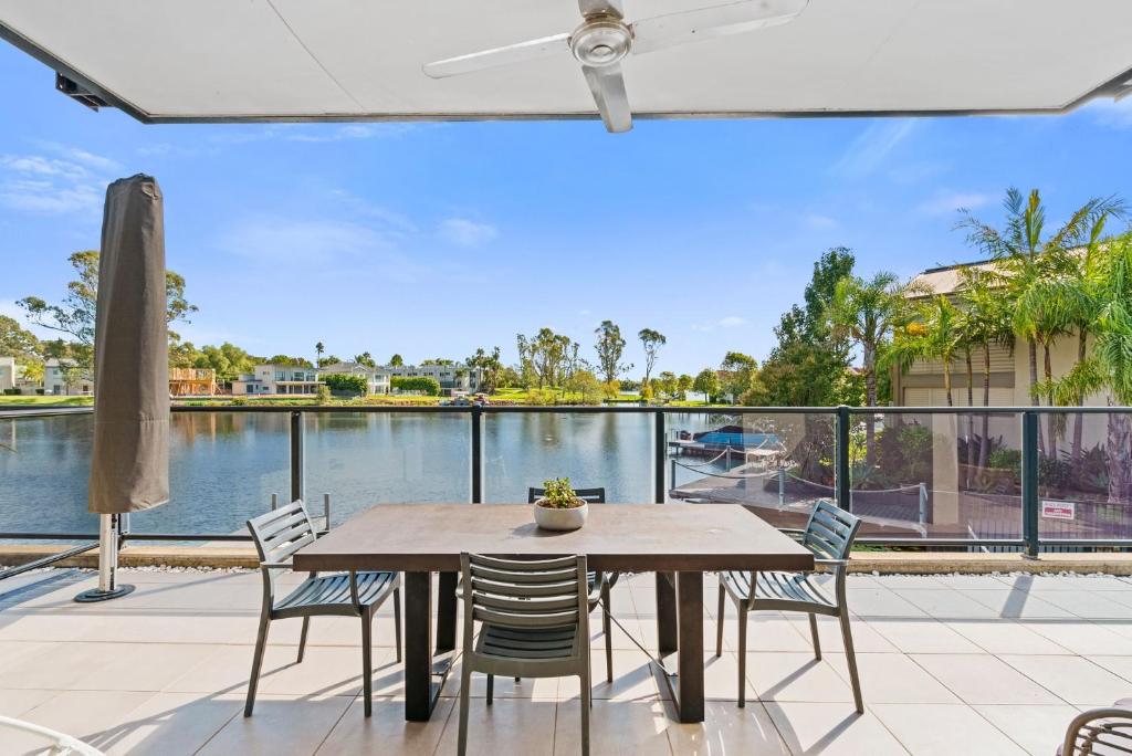 a patio with a table and chairs and a view of the water at The Lake House in Mulwala