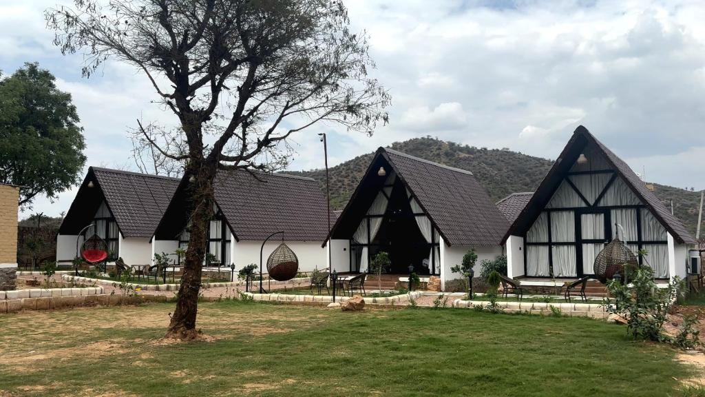 a black and white house with a tree in front of it at THE RiYASAT SARISKA in Ajabgarh