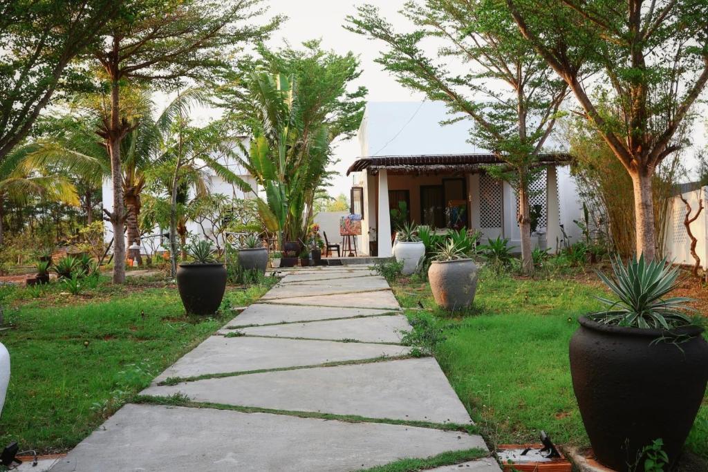 a walkway in front of a house with trees at Art Hill Villas in Kao Kuil