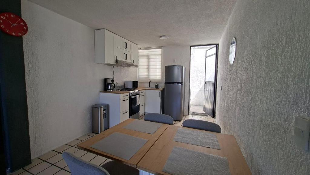 eine kleine Küche mit einem Tisch und einem Kühlschrank in der Unterkunft Casa Torremolinos en Coto Privado in Zapopan