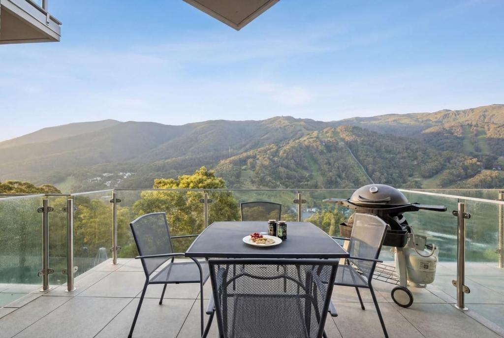 a table and chairs on a balcony with a grill at Lantern 22 - Balcony in Thredbo