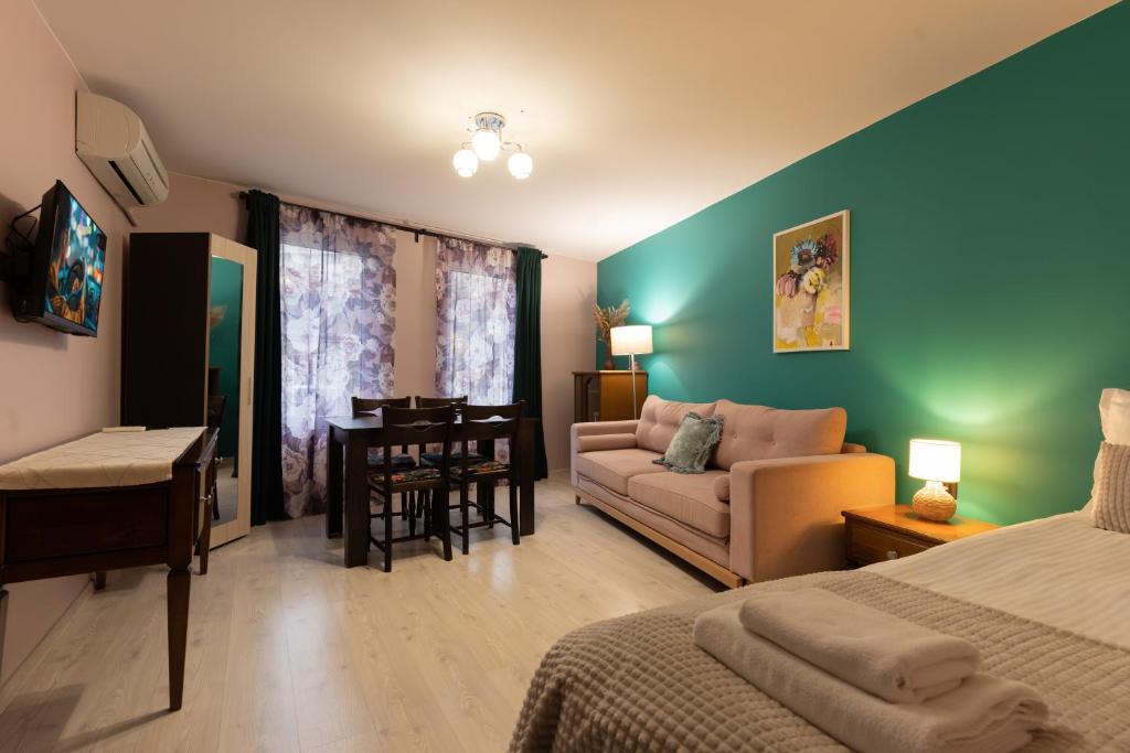 a bedroom with a bed and a couch and a table at Aleko Apartments City Center in Veliko Tŭrnovo