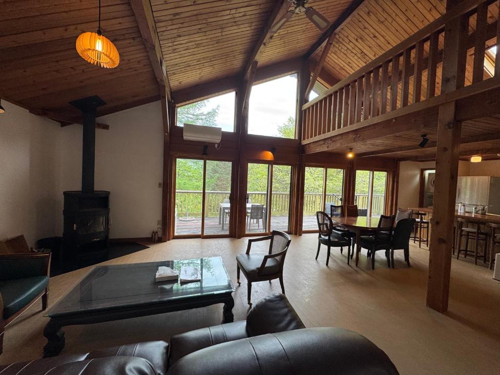 a living room with a couch and a table at Cabin D 3min walk Lake Saiko remote work BBQ, 5min drive Kawaguchi Lake Mt Fuji view in Narusawa