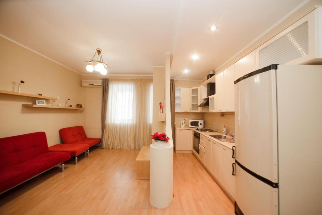 a kitchen with a red couch and a refrigerator at Apartment na Baumana 26 in Kazan