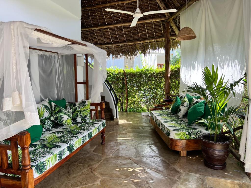 a living room with two couches and plants at Fasha House Malindi in Malindi