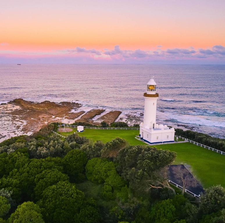 an aerial view of a lighthouse on the ocean at Reflections Norah Head Lighthouse Cottages in Norah