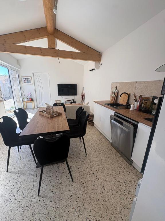 a kitchen and dining room with a table and chairs at La maison de Petit Pierre in Vauvert