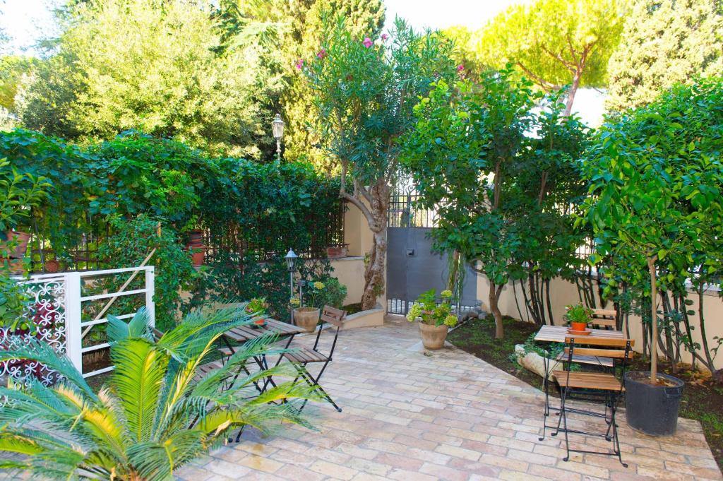 un patio con tavolo, sedie e alberi di B&B Domus Aurea a Roma