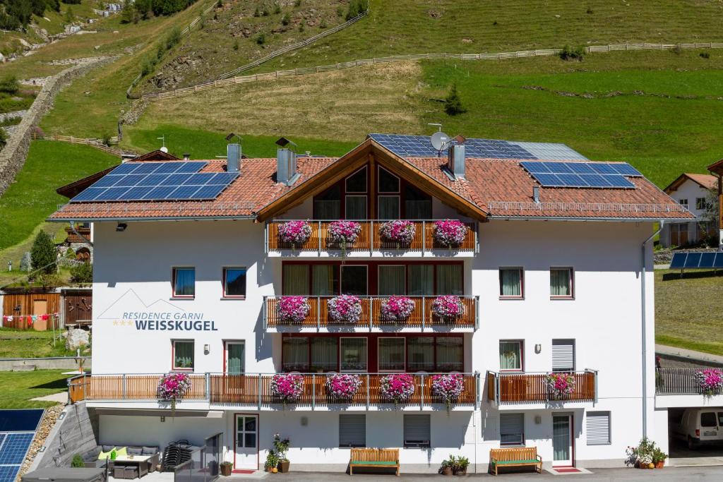 un edificio con paneles solares en el techo en Residence Weisskugel Langtaufers Südtirol en Melago