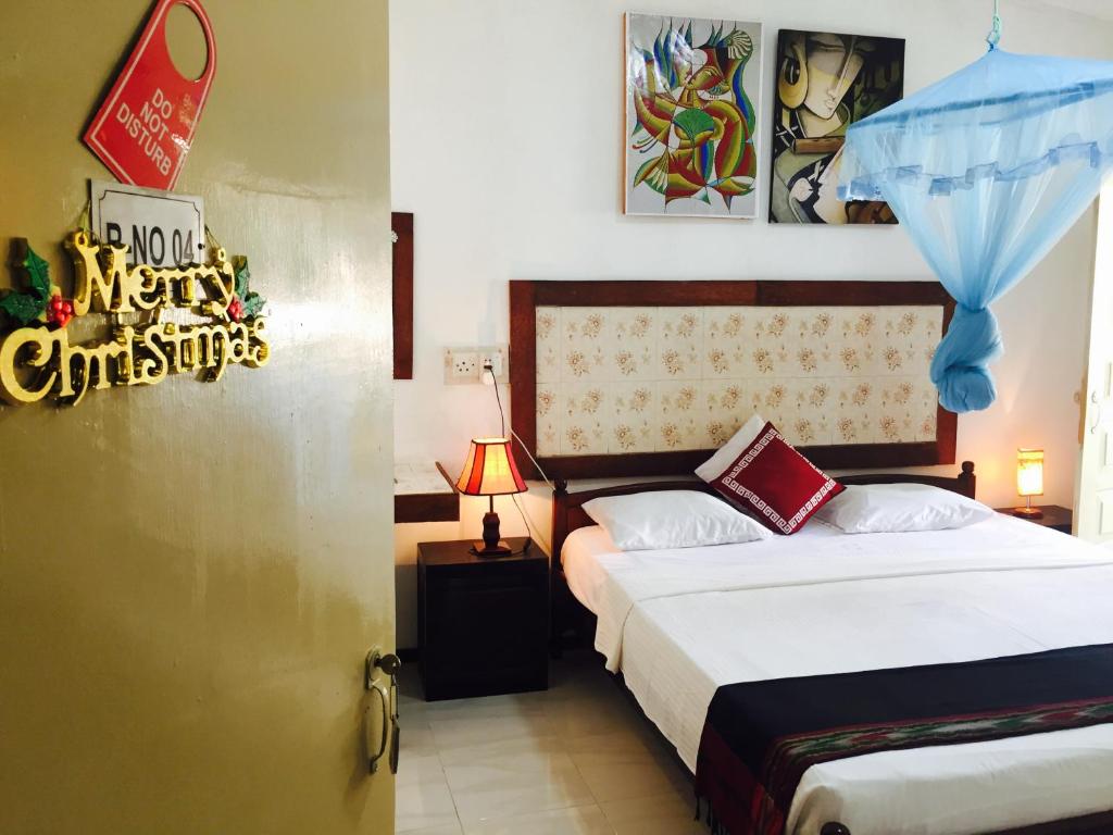 1 dormitorio con 2 camas y un cartel de Navidad en la puerta en Holiday Nest Bed & Breakfast, en Wadduwa