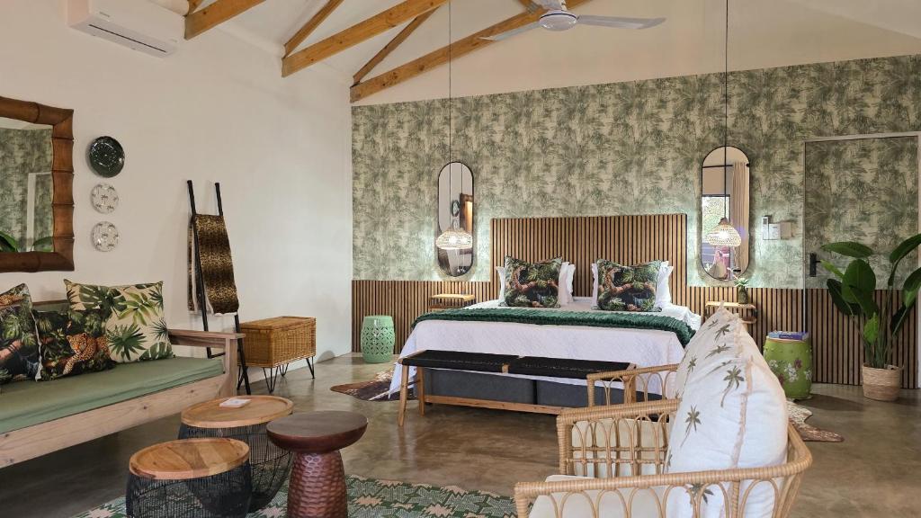 a bedroom with a bed and a couch at Khaya Kwalata in Marloth Park