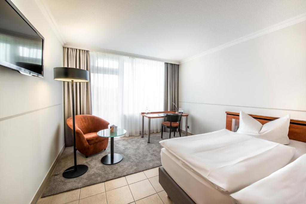 Postel nebo postele na pokoji v ubytování Hotel VierJahreszeiten am Seilersee