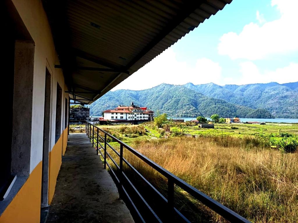 a balcony of a building with a view of the mountains at hotel lakema in Pokhara