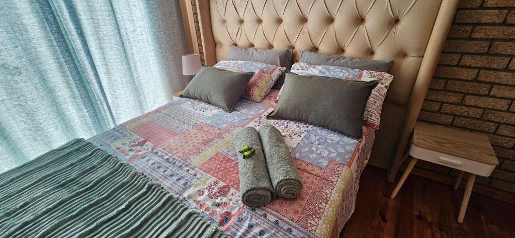 a bed with a quilt and pillows on it at Mountain View in Klein-Brakrivier