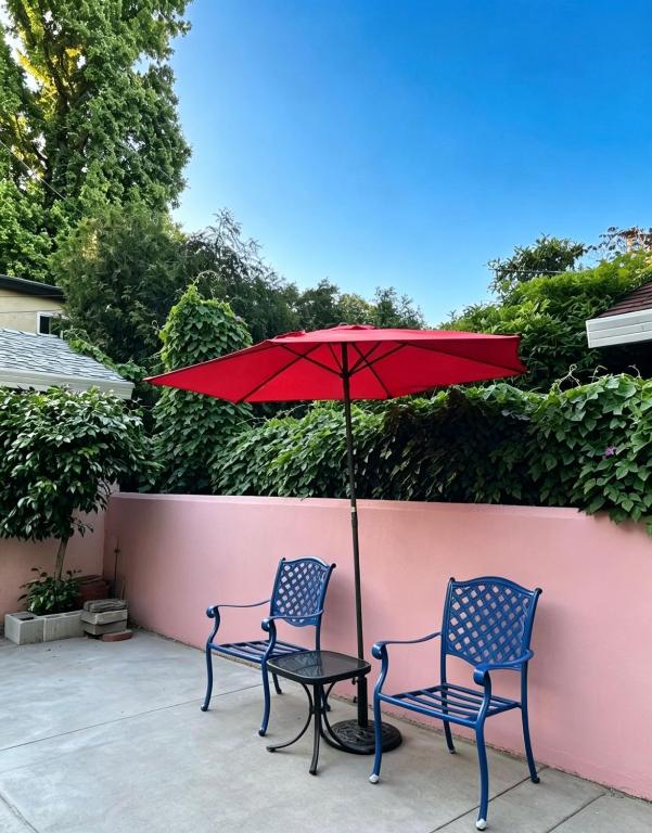 two chairs and a table with a red umbrella at Downtown Private Master Suite in Sacramento