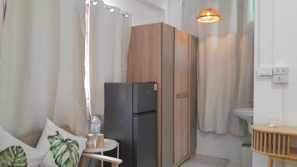 a small kitchen with a black refrigerator in a room at 365house in Ban Phlu Yai