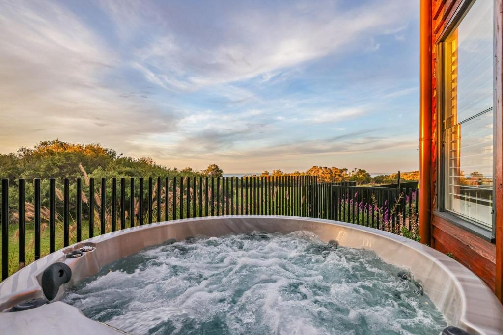 a hot tub in a backyard with a fence at Seaview Escape in Ventnor