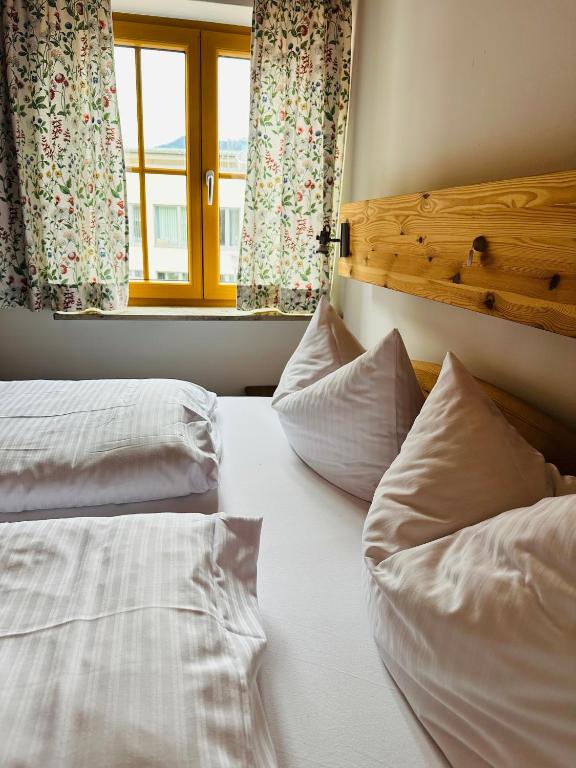 two beds in a room with a window and two pillows at Ferienwohnungen Hänsel und Gretel - zentral, gemütlich, nah am See in Schliersee