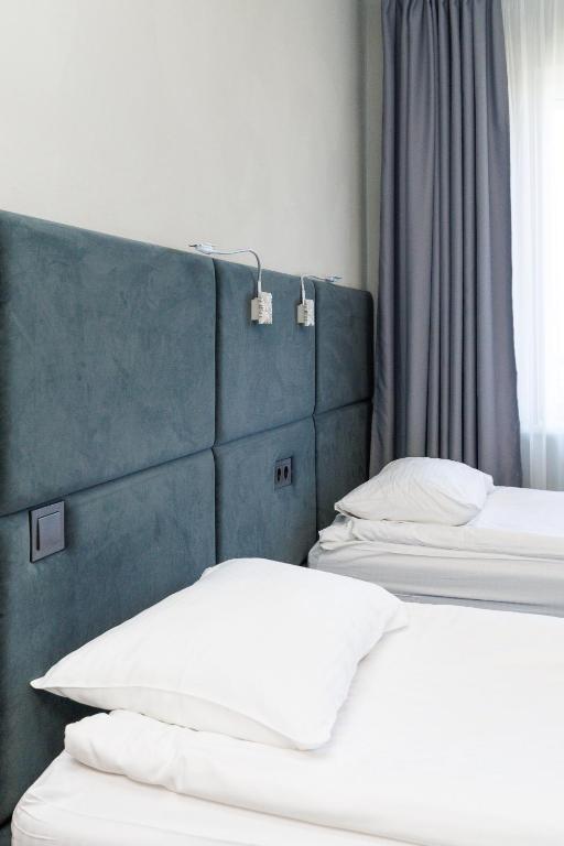two beds with white pillows in a room at Jūratės B&B Namai in Karmėlava