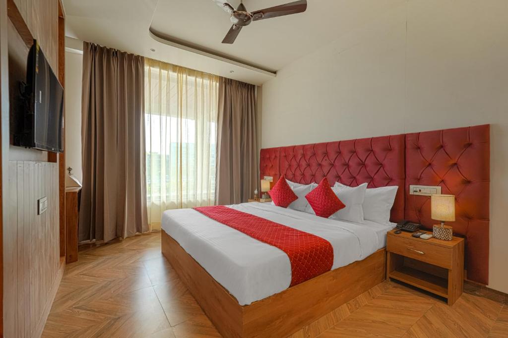 a bedroom with a large bed with a red headboard at Hotel Tranquil Airport Road Sector 66 Mohali Chandigarh in Mohali