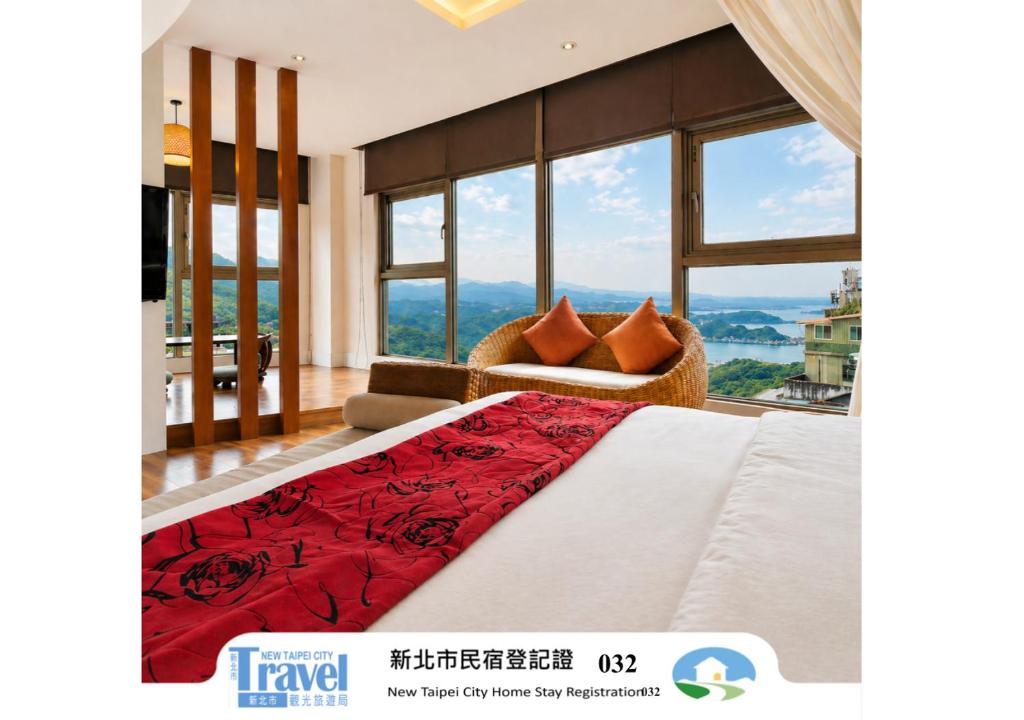 a bedroom with a bed and a couch and windows at Chiu Chunt Dint B&B in Jiufen
