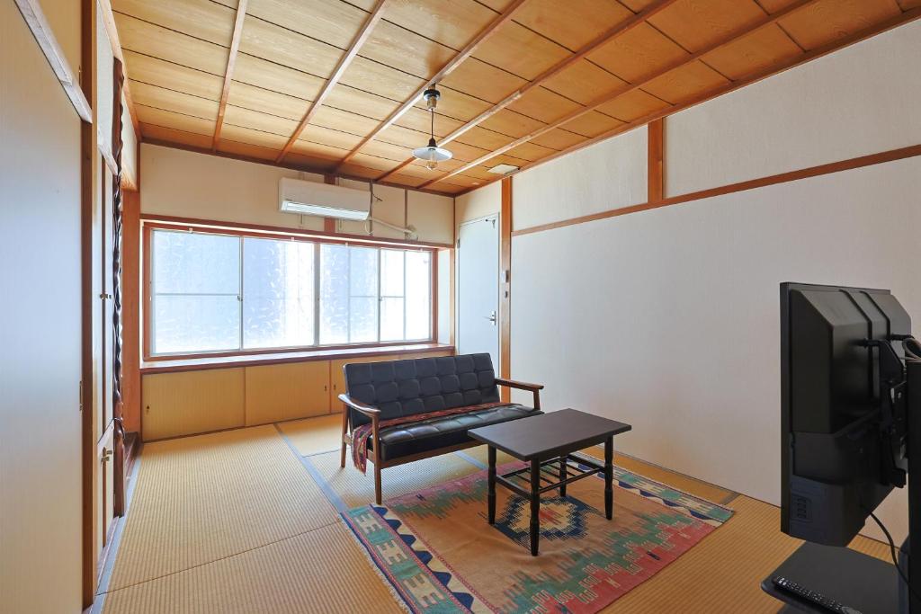 a living room with a couch and a tv at Authentic Local Experience House in Nara