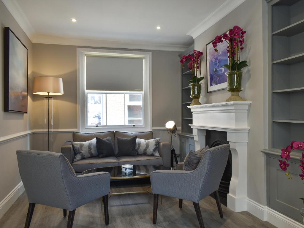 a living room with a couch and a fireplace at The House At One Warwick Park in Royal Tunbridge Wells