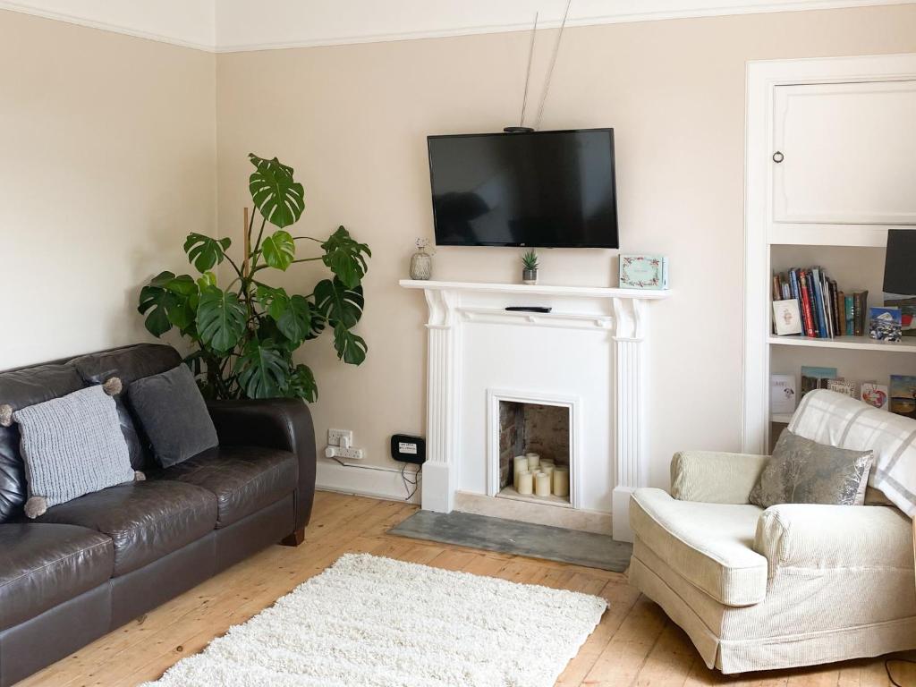 a living room with a couch and a fireplace at The Wee Cottage - Uk42919 in Dunfermline
