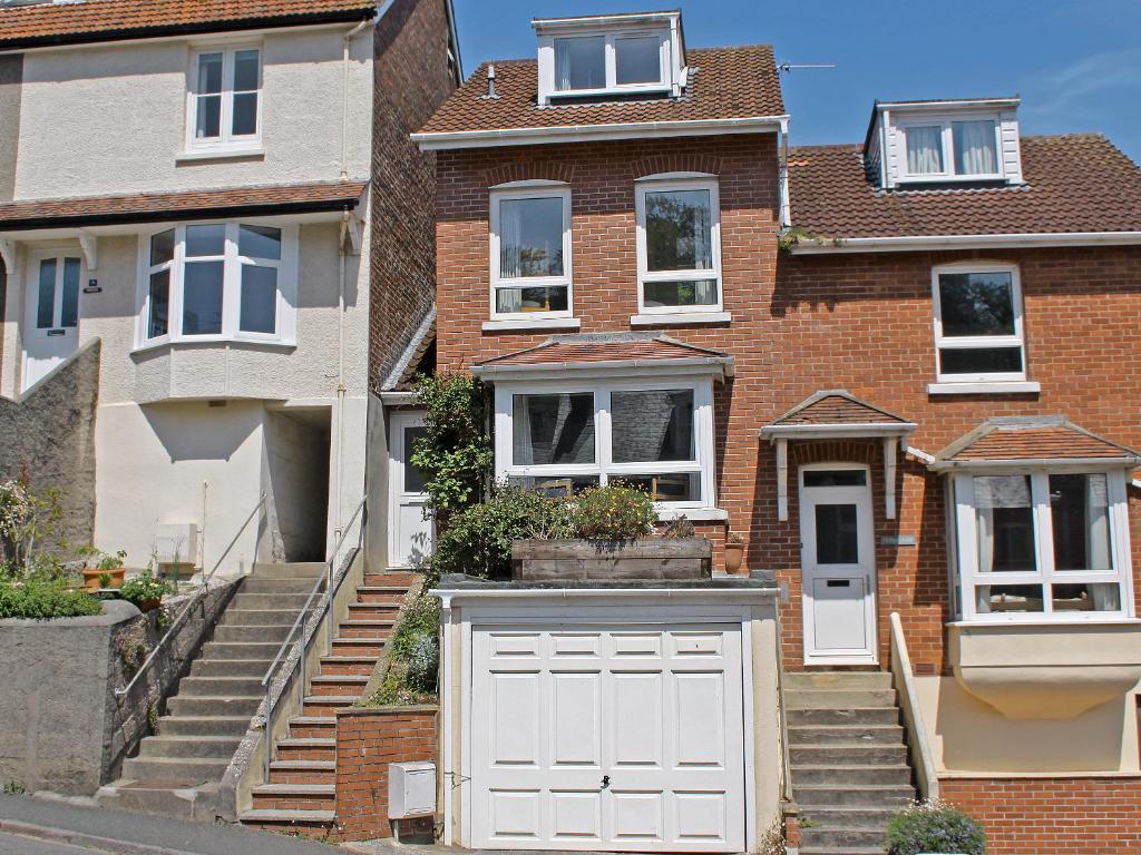 a brick house with a white garage at Oakridge in Salcombe