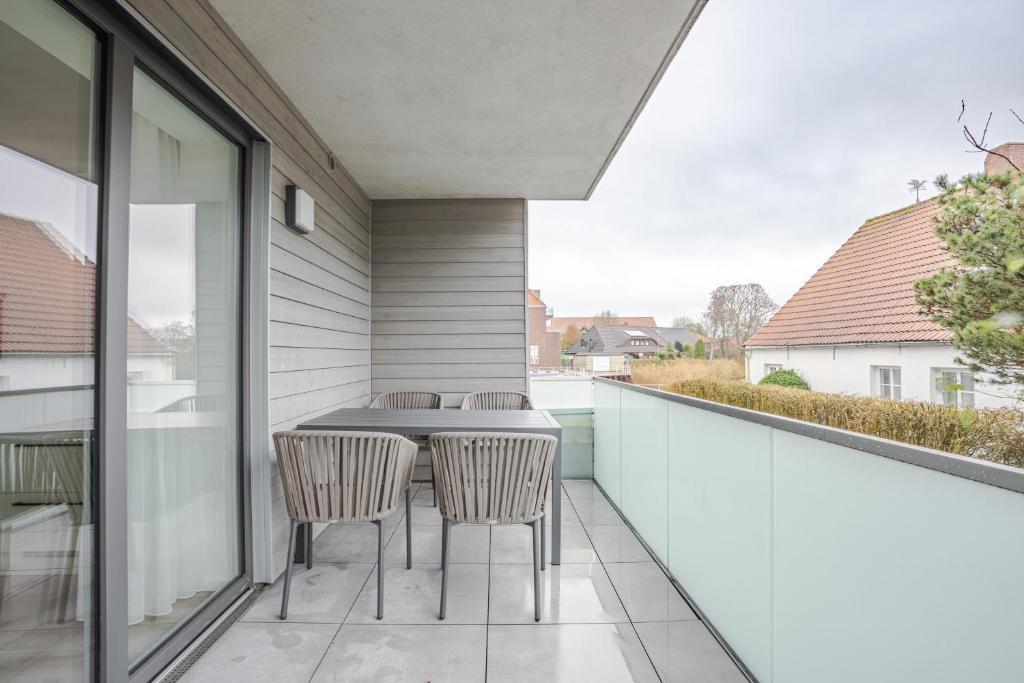 a patio with a table and chairs on a balcony at Nr 301 - Apartmenthaus "Harleblick" in Carolinensiel