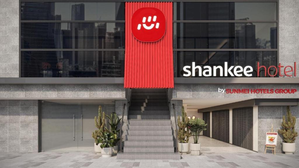 a building with a red sign on the side of it at SHANKEE Hotel Melawai Blok M Jakarta in Jakarta