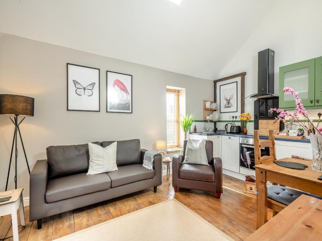 a living room with a couch and a table at The Dairy - Ukc3780 in Hickling