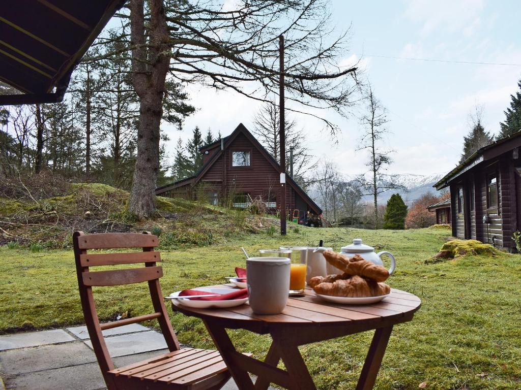 a wooden table with food and drinks on it at Forest View in Strathyre