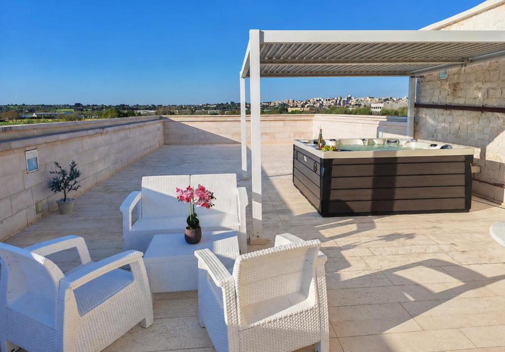 a patio with chairs and a hot tub on a roof at Tenuta Ulivi in Putignano