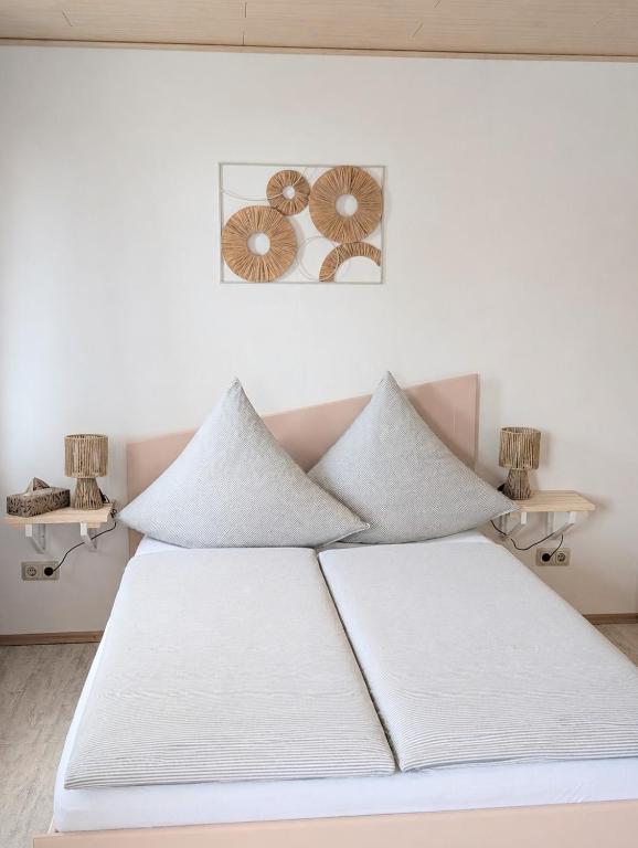 a bed with white sheets and pillows in a room at Blaues Häuschen an der Burg in Neuenstein
