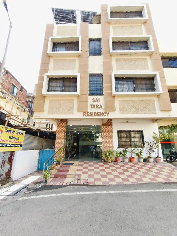 an apartment building with the entrance to an inn residency at Sai Tara Residency in Shirdi