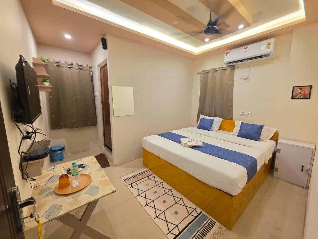 a bedroom with a bed and a table and a television at Vijaya Lodge in Vadalūr