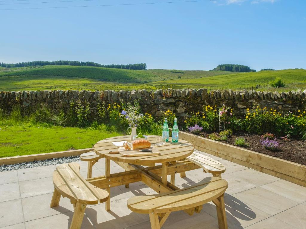 a wooden table and chairs on a patio at West Skeroblin in Campbeltown