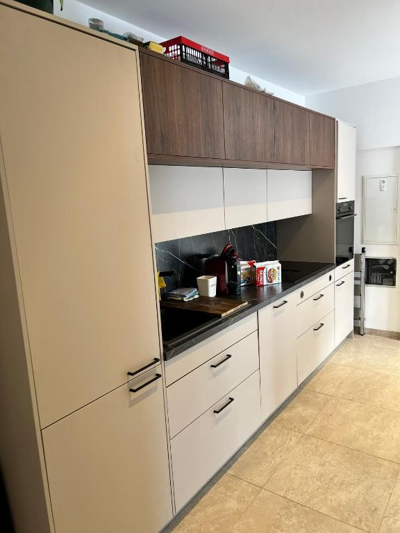 a kitchen with white cabinets and a white refrigerator at Modernes 3-Zimmer Appartement in Wels