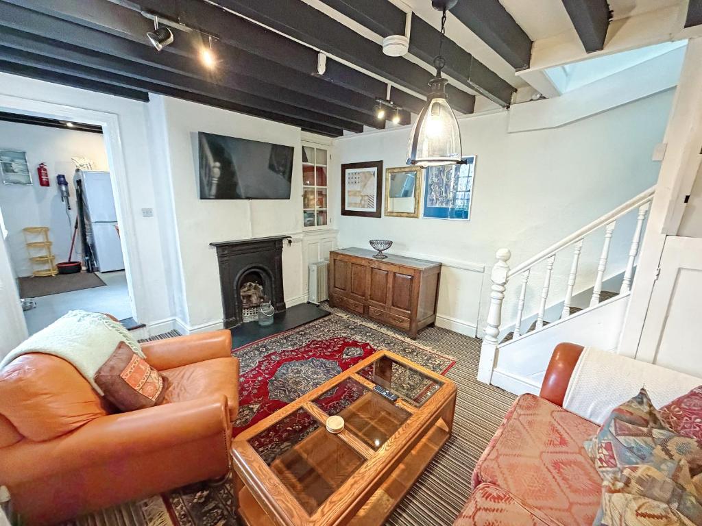 a living room with a couch and a fireplace at The Courtyard Cottage in Llangollen