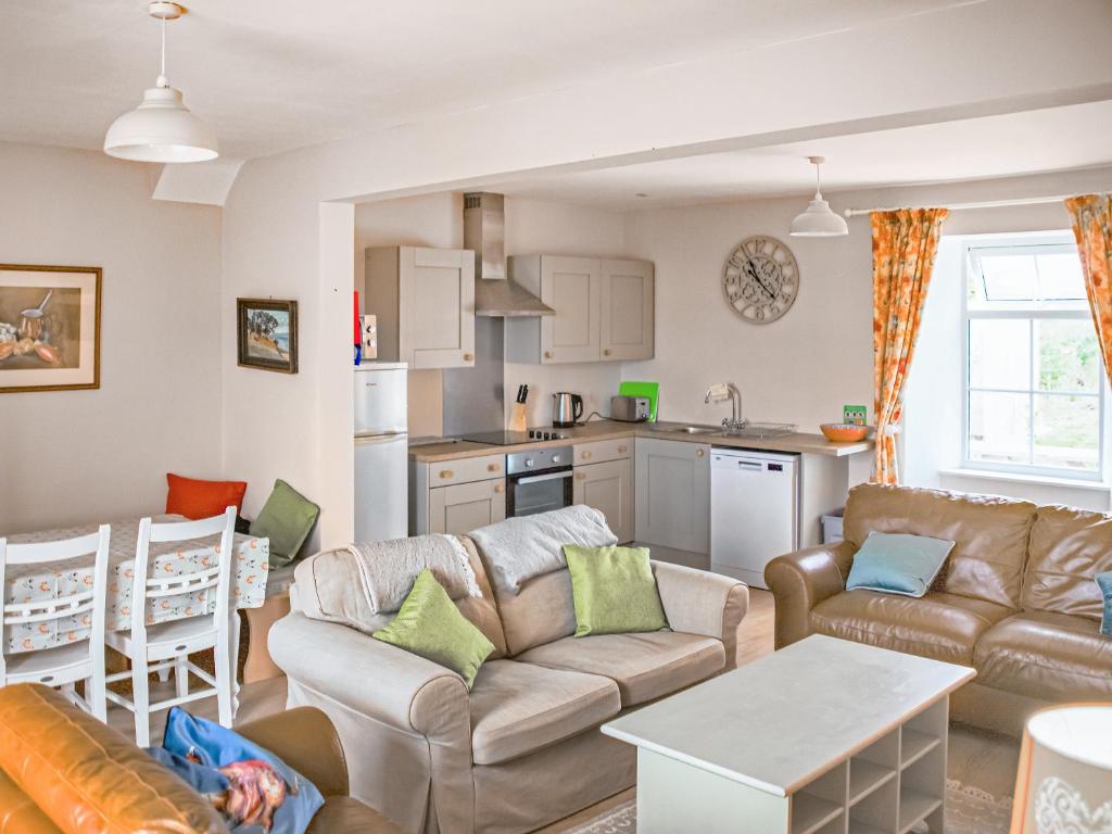 a living room with a couch and a table at Beachcmbers Cottage - Uk51638 in Carsethorn