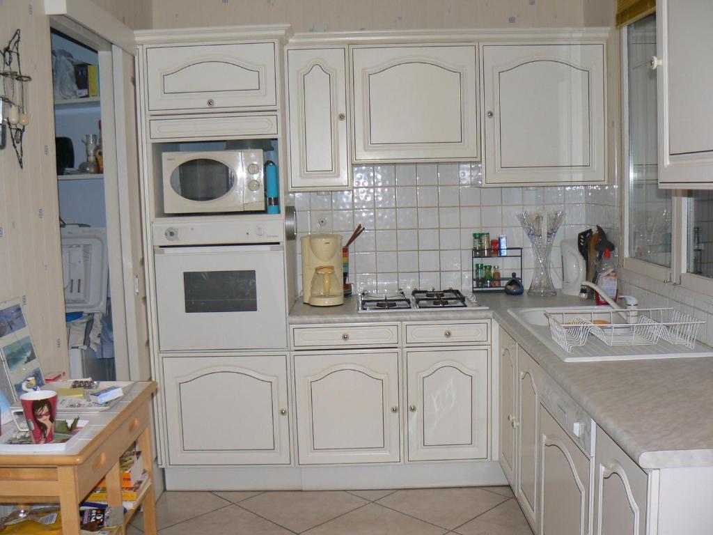 a white kitchen with white cabinets and a microwave at Chambre lit simple in Saint-Herblain