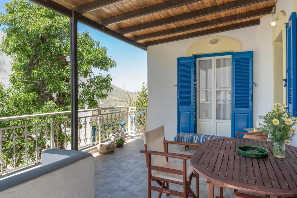 a patio with a wooden table and chairs at Hippocrates' House in Amorgos