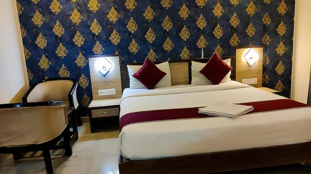 a hotel room with a bed and a chair at Royal shades kodihali in Bangalore