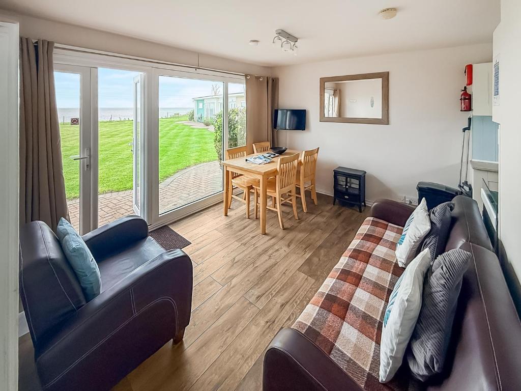 a living room with a couch and a table at No 4 Hickling Chalet - Uk51729 in Scratby