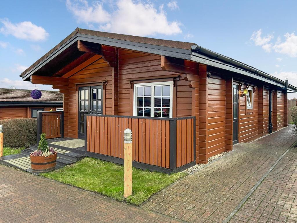 a small wooden house with a fence at Lodge 3 - Uk51250 in Glasgow