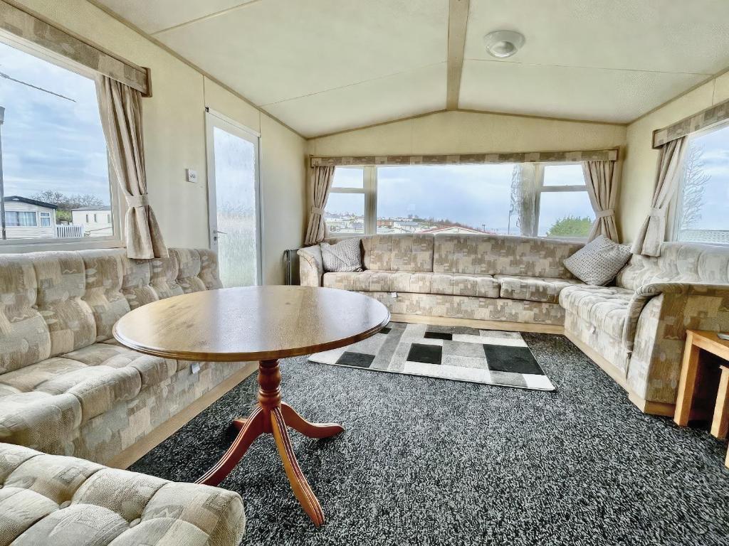 a living room with couches and a table at The Medway - Uk51004 in Eastchurch